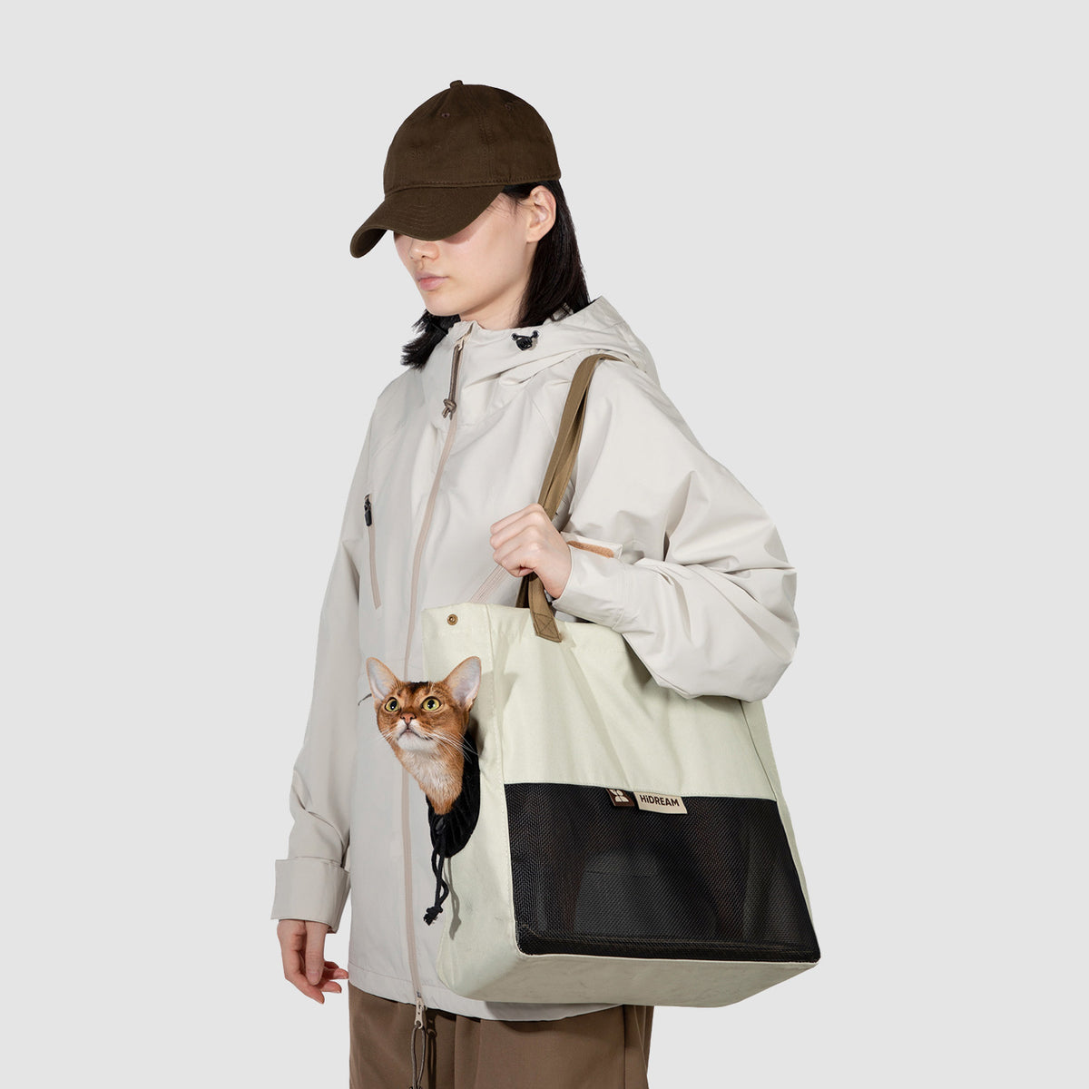 Person carrying a pet carrier tote with a small pet during an everyday outing