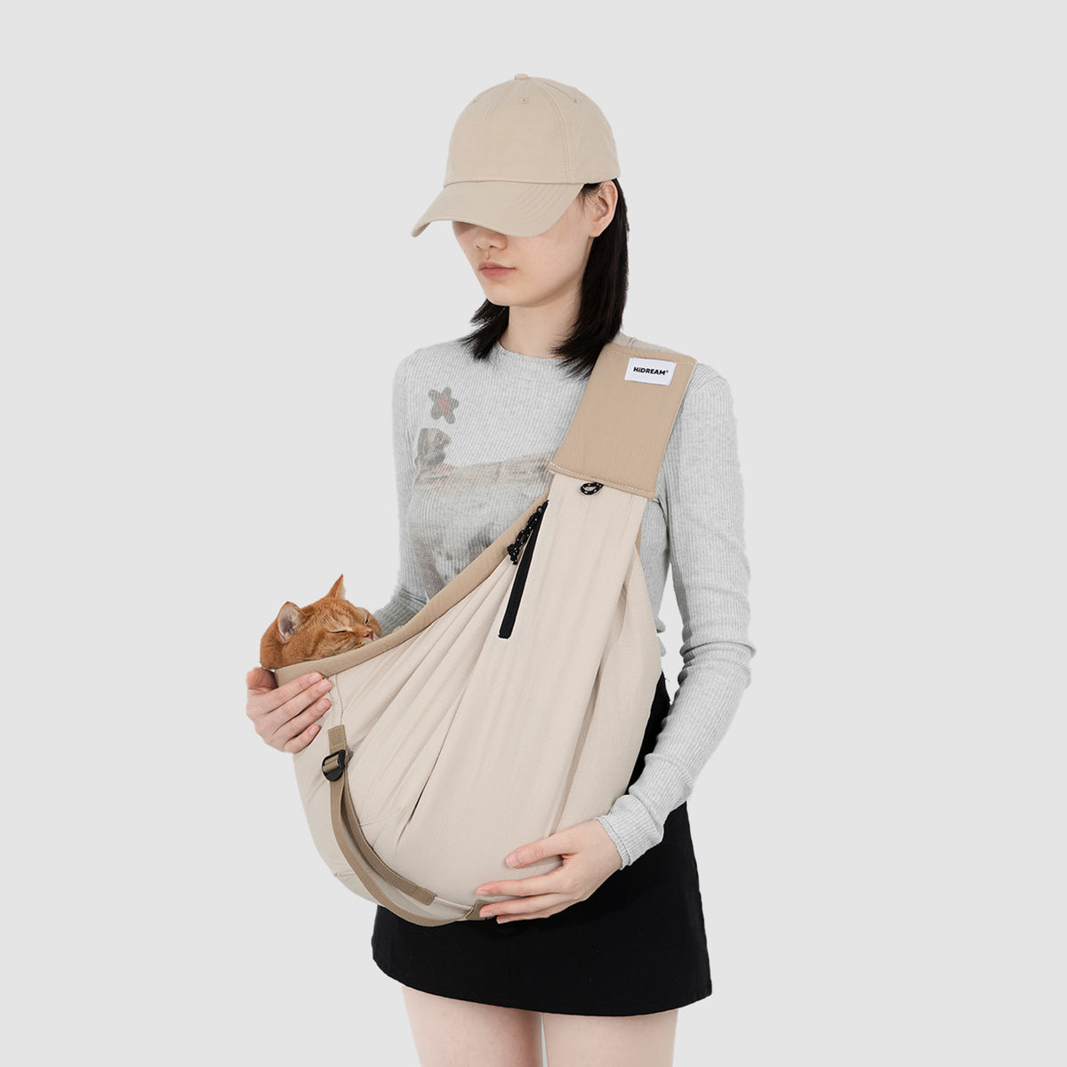 Person wearing a pet sling carrier with a small pet kept close during everyday outings